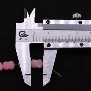 Roze strikvormige kraal van 12 mm gemeten met een schuifmaat voor doe-het-zelf sieraden