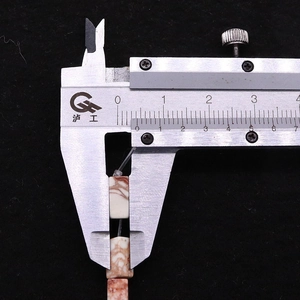 Macro view of 4x8mm rectangular stone beads measured with a digital caliper