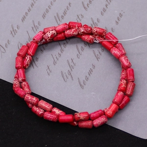 Close-up of red imperial jasper tube beads with natural marble texture for DIY jewelry