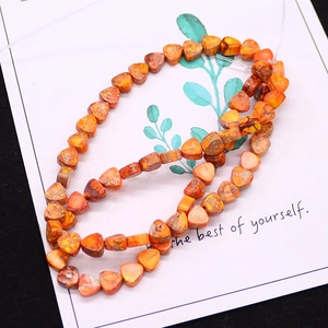Macro view of orange heart-shaped natural imperial stone beads for DIY jewelry making