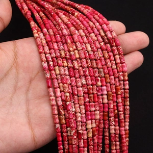 Gros plan de perles en jaspe impérial rouge en forme de tonneau pour bijoux DIY