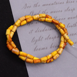 Macro detail of cylindrical imperial stone beads with polished natural orange textures