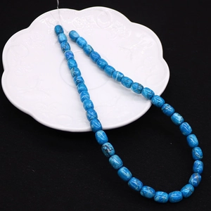 Blue drum-shaped imperial stone beads for DIY jewelry making displayed on a ceramic plate