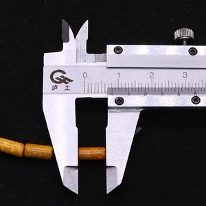 Measuring orange cylindrical stone bead with calipers for DIY jewelry making