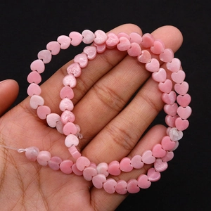 Macro detail of heart-shaped pink natural stone beads for DIY jewelry making