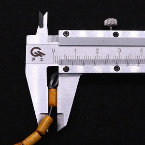 Detailed measurement of a 10mm yellow cylinder natural stone bead with a digital caliper