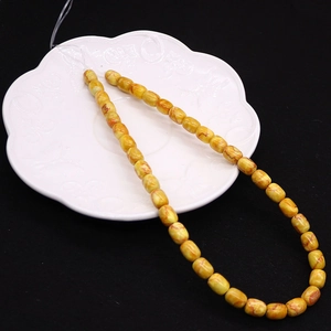 Macro detail of 8x10mm yellow emperor stone drum beads with natural red texture for DIY