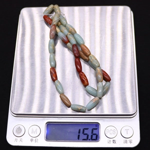 Détail de perles ovales en pierre impériale sur une balance pesant 15,6g pour bijoux DIY