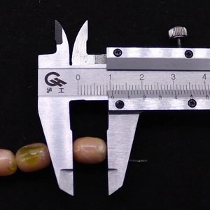 Macro shot of pink oval emperor stone beads showing 10mm size measurement on calipers