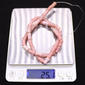 Gros plan de perles en pierre naturelle rose en forme de bambou pour bijoux DIY