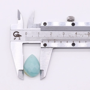Detailed measurement of a faceted teardrop natural stone pendant using a metal caliper