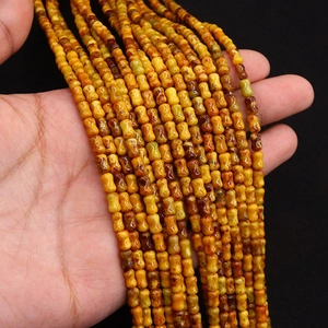 Détail macro de perles en pierre d'empereur jaune en forme d'os pour bijoux DIY