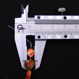 Misurazione di perline in pietra naturale a goccia 6x8mm con un calibro di precisione