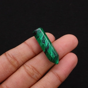 Detailed macro view of a natural malachite hexagonal prism with green striped textures