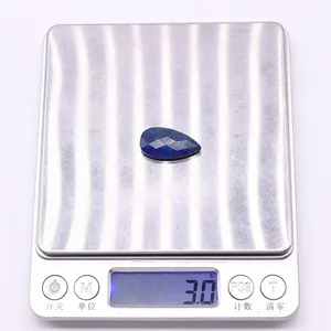 Detailed macro view of a 3g teardrop lapis lazuli stone on a digital scale for precision