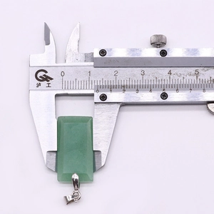 Close-up of green aventurine stone pendant with silver clasp measuring 16mm on a caliper