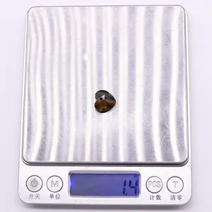 Detail shot of heart-shaped faceted gemstone weighing 1.4g on a silver digital scale