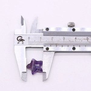 Detailed measurement of a star-shaped purple amethyst stone using a professional caliper