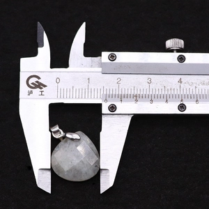 Macro view showing natural stone droplet pendant measured with a digital caliper