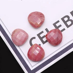 Detail macro-opname van vier hartvormige gefacetteerde roze edelstenen met natuurtextuur