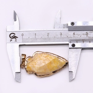 Pendentif en pointe de flèche mesuré au pied à coulisse montrant une largeur de 3,7 cm