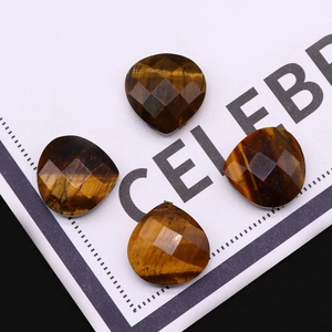 Macro-opname van vier gefacetteerde hartvormige tijgeroog kralen voor DIY sieraden