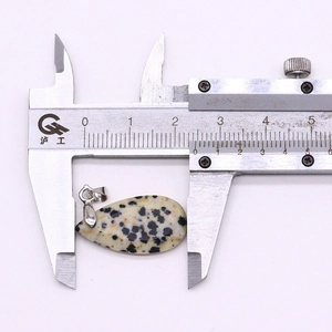 Digital caliper measuring the 26.5mm width of a teardrop Dalmatian Jasper stone pendant