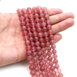 Handheld bundle of natural pink strawberry quartz beads for DIY jewelry making