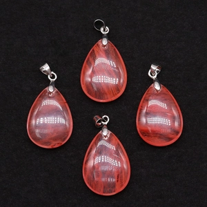 Macro view of four red teardrop crystal pendants with natural inclusions and silver bails