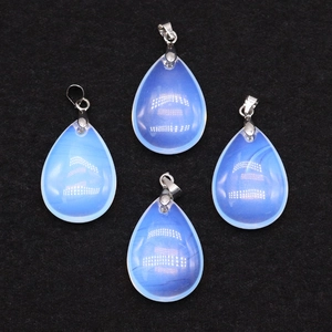 Close-up of four opal teardrop pendants with silver bails on black velvet background