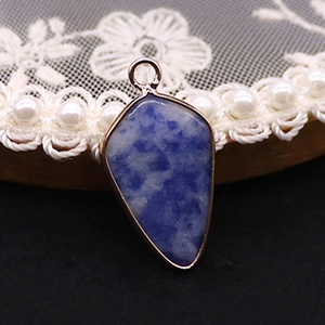 Détail du pendentif en pierre de sodalite bleue avec bords en métal doré poli