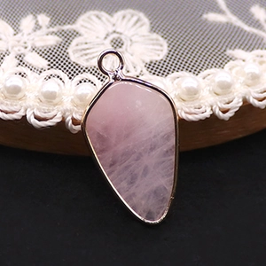 Vue détaillée d'un pendentif en quartz rose avec placage doré et texture de pierre