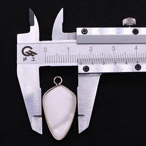 Vue macro de la mesure de largeur du pendentif triangle en pierre naturelle et or
