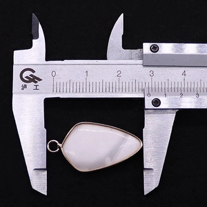 Vue macro détaillée montrant la mesure de largeur de 2,8 cm du pendentif bouclier blanc