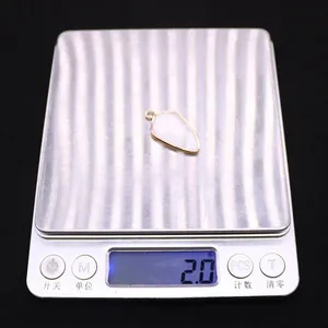 Macro view of natural stone shield pendant on digital scale weighing 2.0 grams