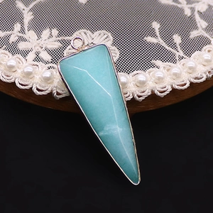 Primer plano de un colgante de piedra natural triangular con bordes dorados para joyas