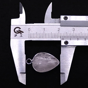 Detail view of a teardrop gemstone pendant being measured with a caliper at 20mm width