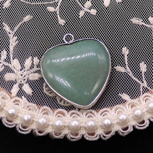Detailopname van hartvormige groene natuurstenen hanger met een verzilverde metalen rand