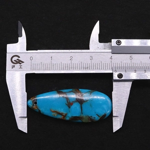 Makroaufnahme von Türkis-Tropfenanhänger mit Messung von 41 mm Länge auf einem Messschieber