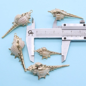 Macro-opname van een vergulde schelphanger met schuifmaat die de 2,5 cm afmeting toont