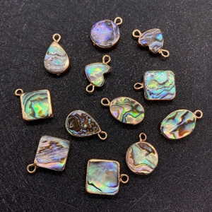 Détail des breloques en nacre d'abalone en forme de cœur et rondes pour bijoux DIY
