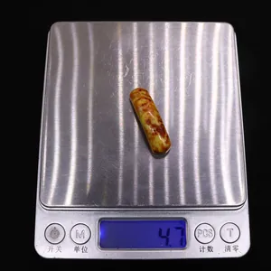 Vista macro de un colgante de piedra imperial de 4,7g en una báscula digital de precisión