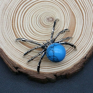 Detailed view of silver spider pendant with blue marbled stone on wooden background