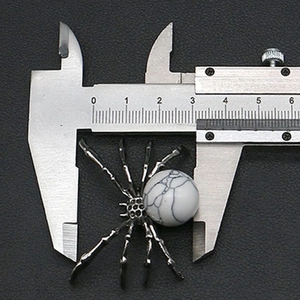 Detail showing spider pendant dimensions of 33mm measured by a caliper tool