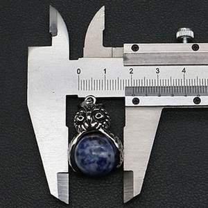 Macro di un ciondolo a forma di gufo largo 18 mm con pietra naturale blu incastonata