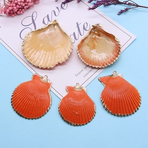 Vue détaillée de pendentifs coquillages colorés avec bords dorés sur fond bleu