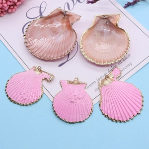 Détail de pendentifs en forme de coquillage rose avec bordure dorée pour création de bijoux
