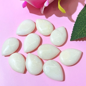 Détail de dix pierres précieuses blanches en forme de goutte sur fond rose vif