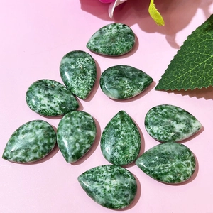 Macro detail of ten teardrop-shaped green agate stones on a pink background