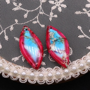 Detalle macro de colgantes de turquesa en forma de marquesa con vibrantes tonos azul y rosa